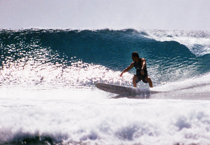 Larry Leight auf seinem Surfboard vor einer großen Welle. Er war viele Jahre lang ein erfolgreicher Wellenreiter.