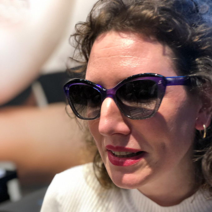 Olivia Delorme, Brillendesignerin für die dänische Kollektion Orgreen mit einer lilafarbenen Acetat-Sonnenbrille, die sie selbst entworfen hat.