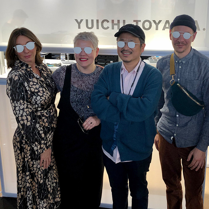 Yuichi Toyama mit einem Teil des BELLEVUE Teams auf der Messe OPTI in München mit weißen, undurchsichtigen Brillen