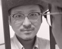 Yuichi Toyama, Gründer und Inhaber der Kollektion Yuichi Toyama mit leichtem Lächeln in einen Spiegel blicken.d