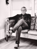 Henrik Lindberg, der ehemalige Inhaber von Lindberg, mit einem Lächeln auf einem typisch nordischen Sofa sitzend.